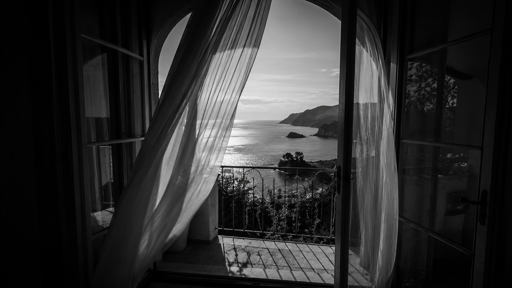 Offenes Fenster mit wehendem Vorhang, Blick auf die Küste